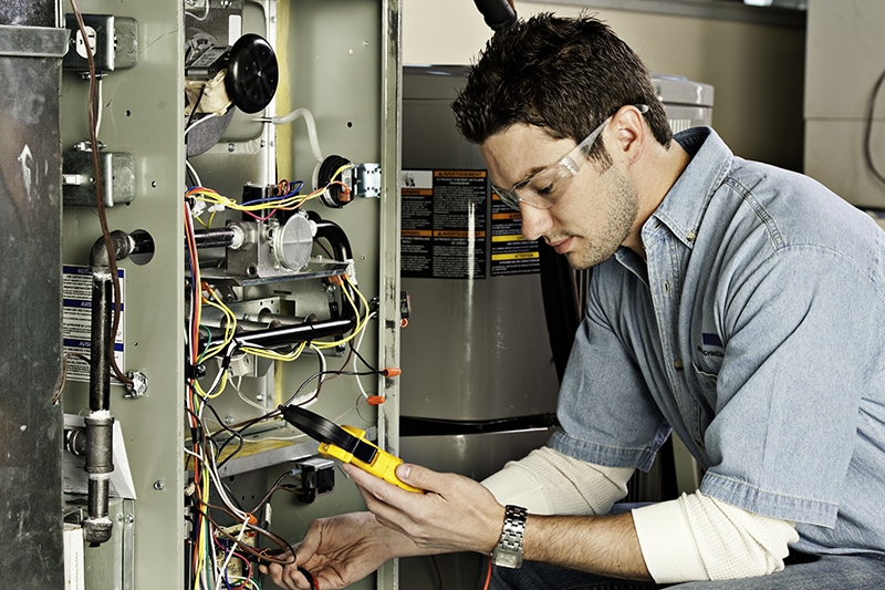 Service Technician performing maintenance on an air conditioning unit